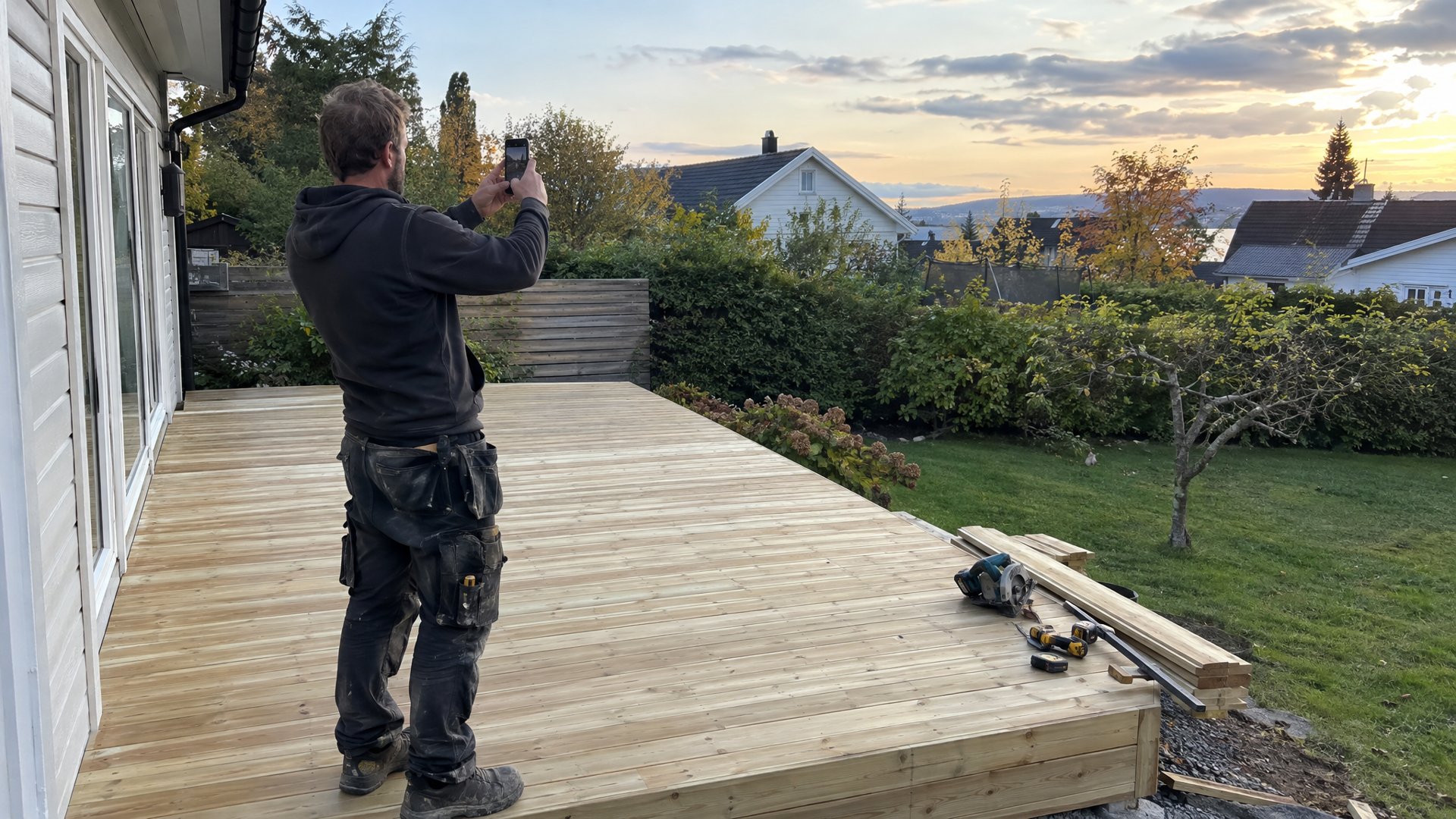 Snekker tar bilde av en nybygd terrasse med mobilen